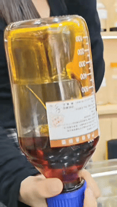 100 percent pure Hainan Resin-Shell (Kezi-Liao) Aged Oud Oil slowly dripping on a glass tube, showcasing its dark waxy density and zero-char authentic quality from our 70-year legacy factory