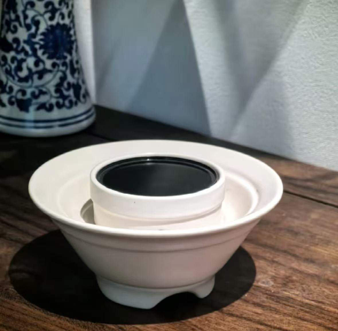 An extra-large museum-grade piece of Hainan Agarwood resin shell diffusing smoke-free vapor on the wide expansion heating ceramic plate inside a high-end luxury Majlis living space