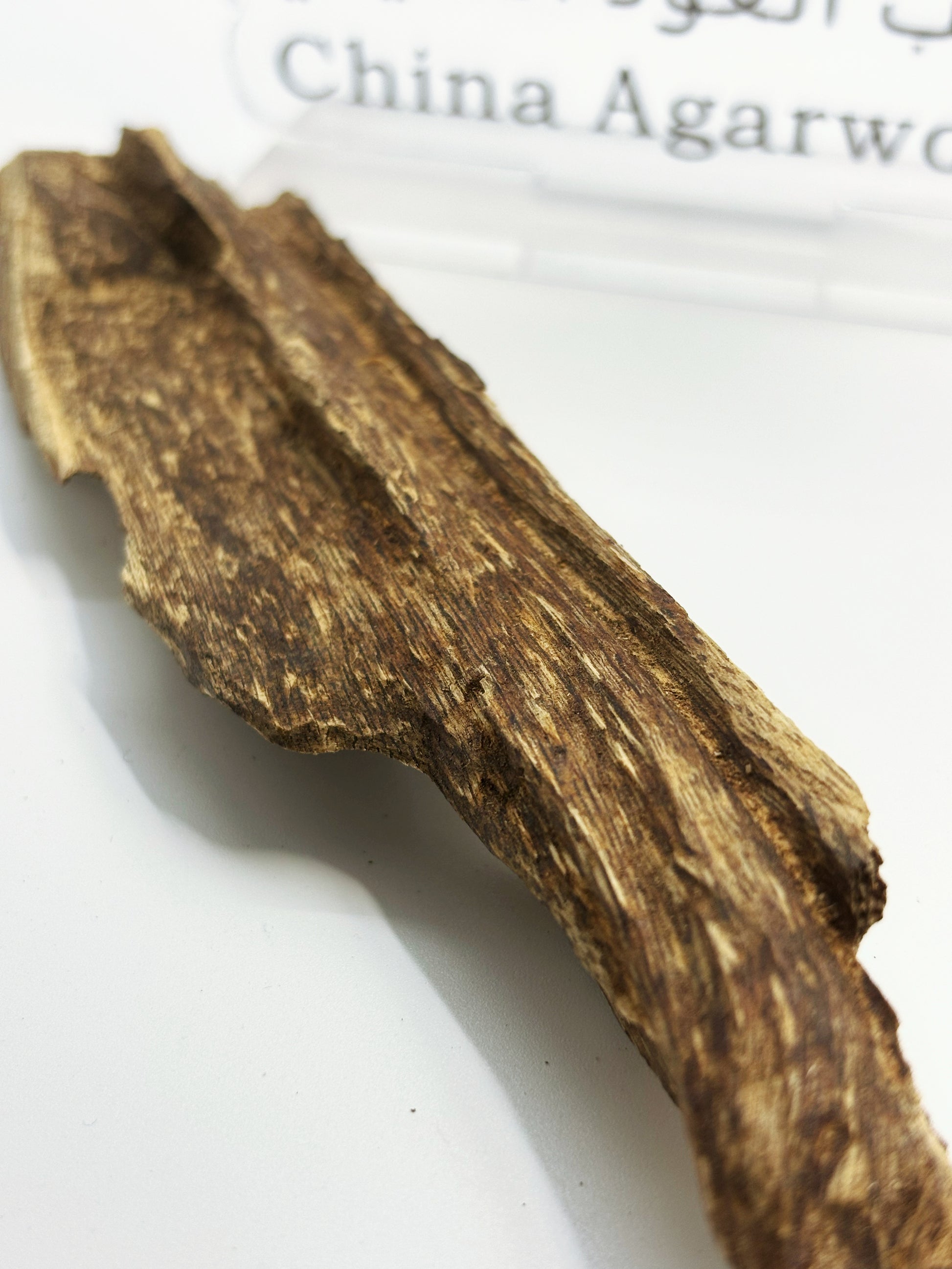 Close-up of 4A grade Hainan agarwood chunks showing natural insect-hole resin veins